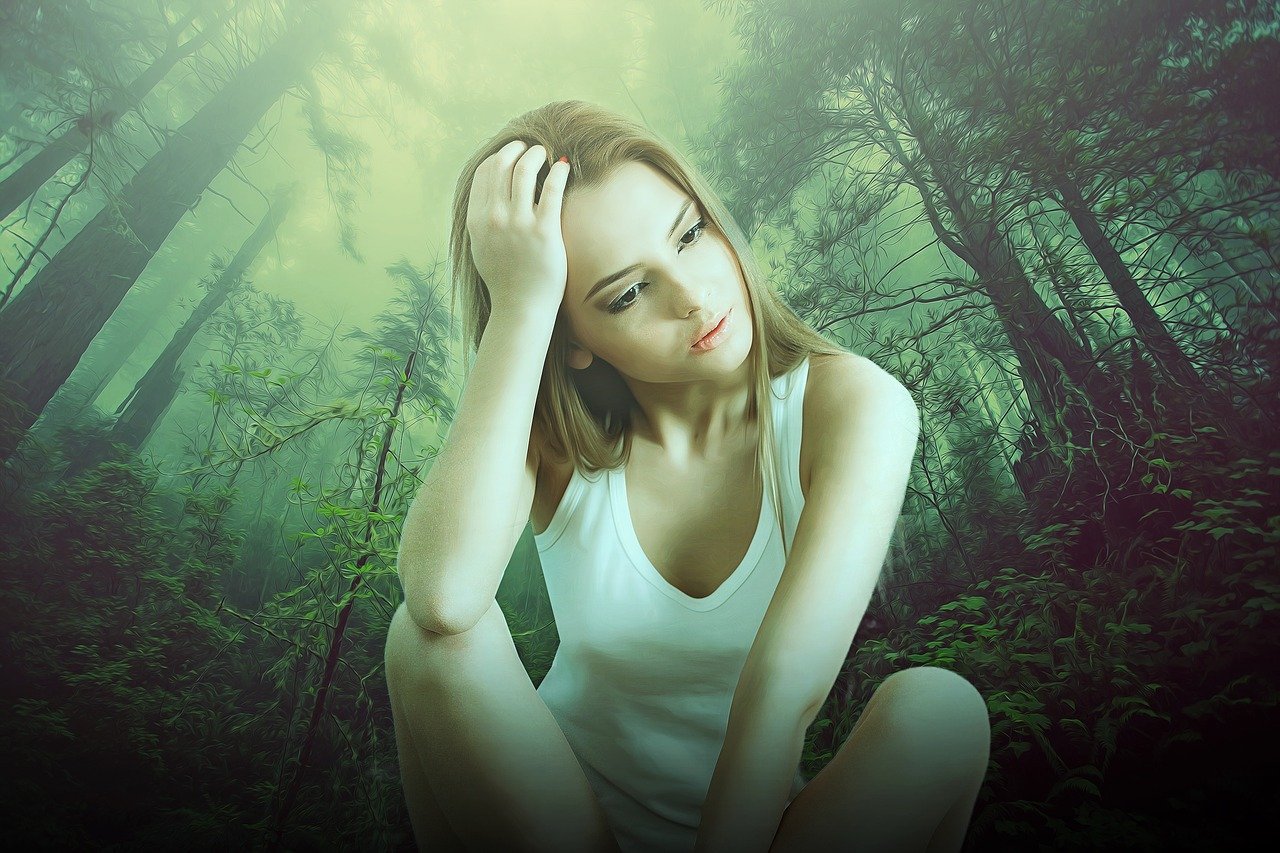 Frau sitzt im Wald und denkt nach. Menschenfreund.net - pixabay